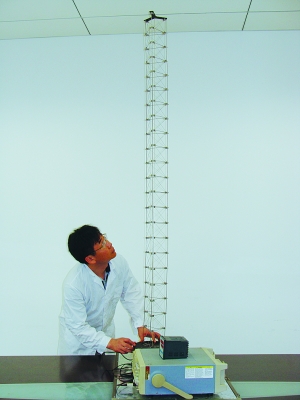 這是伸展開(kāi)的衛(wèi)星太陽(yáng)能電池用盤壓伸桿，20厘米長(zhǎng)螺旋狀的盤壓伸桿（右側(cè)小圖）打開(kāi)后能達(dá)2米長(zhǎng)（8月7日攝）。（新華社發(fā)）
